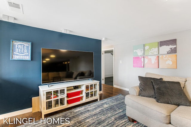 living area with visible vents, baseboards, and wood finished floors