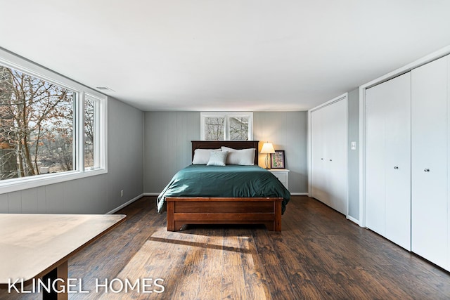 bedroom with visible vents, multiple closets, and wood finished floors