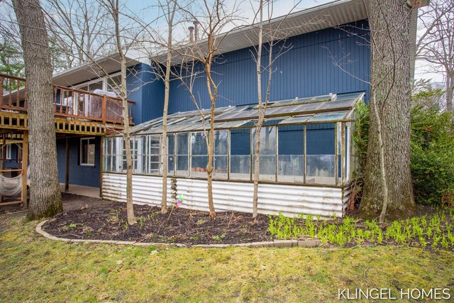 back of house featuring a sunroom and a deck