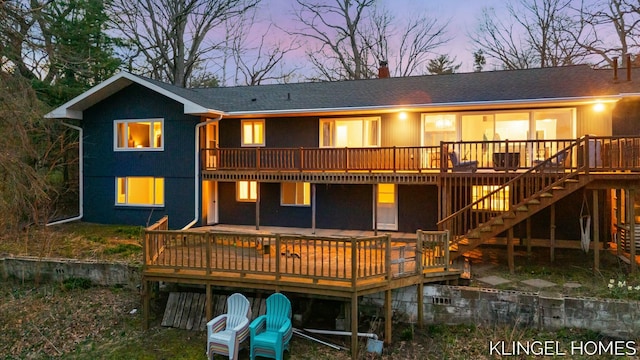 rear view of house with a wooden deck and stairway