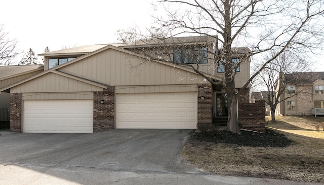 view of front of property with a garage, brick siding, and driveway