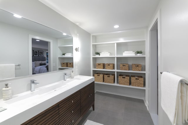 ensuite bathroom featuring built in features, double vanity, recessed lighting, a sink, and connected bathroom