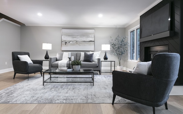 living room featuring crown molding, baseboards, and wood finished floors