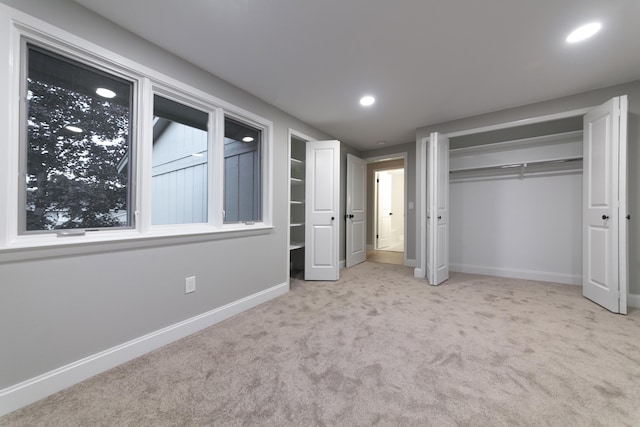 unfurnished bedroom featuring recessed lighting, baseboards, carpet floors, and a closet