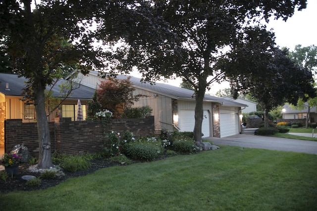 view of front of home featuring brick siding, an attached garage, concrete driveway, and a front lawn