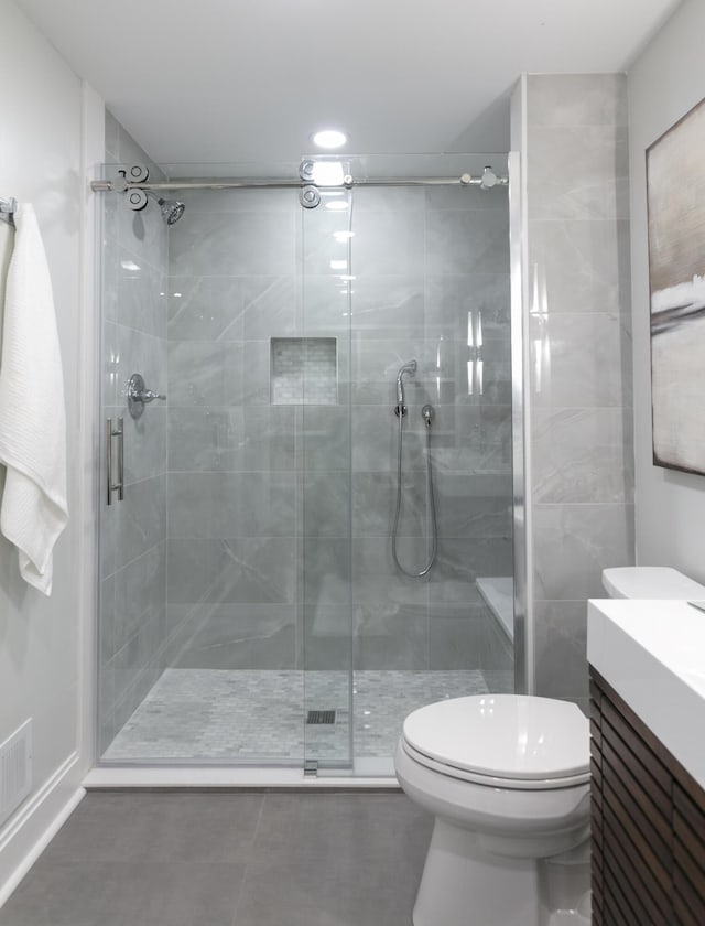 bathroom with vanity, a shower stall, toilet, and tile patterned flooring