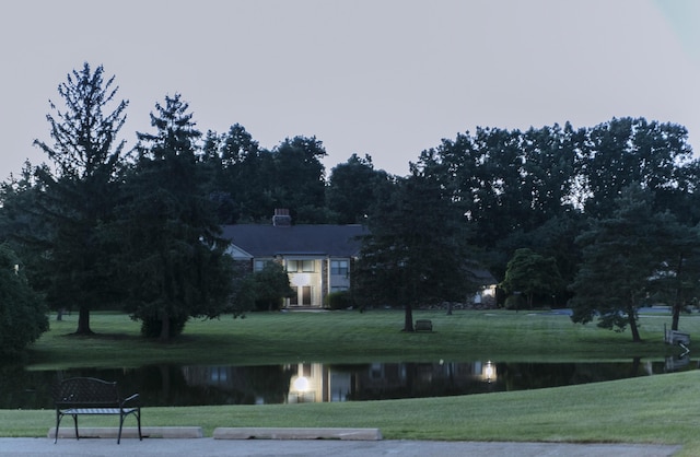 view of home's community featuring a water view and a lawn