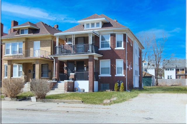 view of front of property with brick siding, covered porch, and a balcony