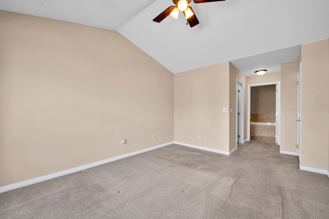 carpeted empty room featuring baseboards, lofted ceiling, and a ceiling fan