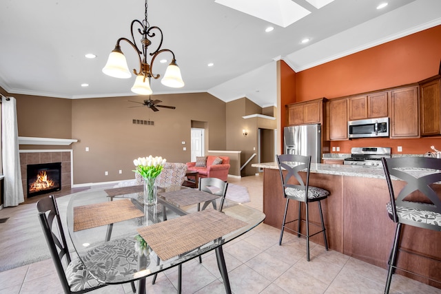 kitchen with visible vents, ceiling fan with notable chandelier, appliances with stainless steel finishes, a skylight, and brown cabinets