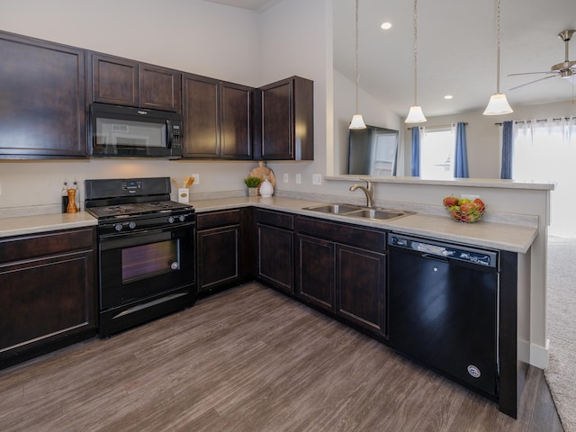 kitchen with a peninsula, a sink, black appliances, dark brown cabinetry, and light countertops