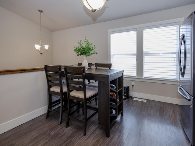 dining space featuring visible vents, a notable chandelier, dark wood-style floors, and baseboards