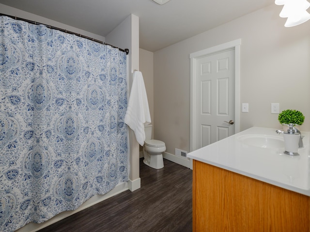 full bathroom featuring visible vents, baseboards, toilet, wood finished floors, and vanity