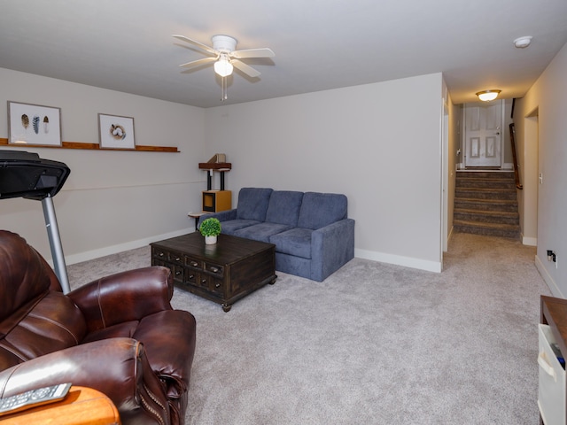 living area featuring stairway, a ceiling fan, baseboards, and carpet floors