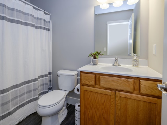 full bathroom with curtained shower, toilet, vanity, and wood finished floors