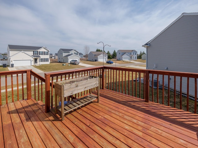 wooden deck featuring a residential view and a lawn