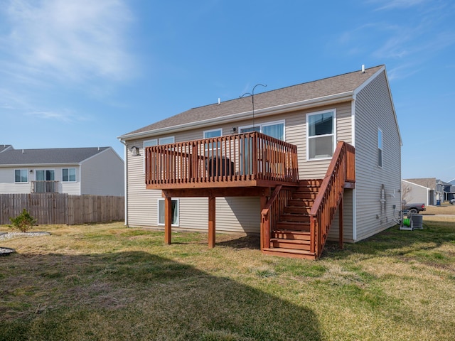 rear view of house with a deck, stairway, a yard, and fence