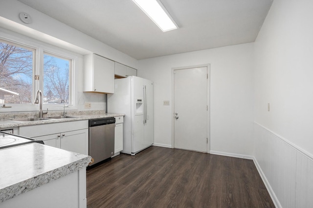 kitchen featuring stainless steel dishwasher, white cabinetry, white fridge with ice dispenser, light countertops, and dark wood-style flooring