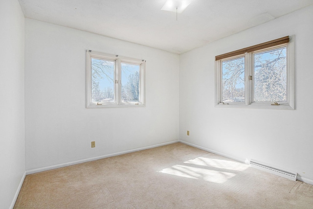 carpeted empty room featuring baseboards and a baseboard radiator