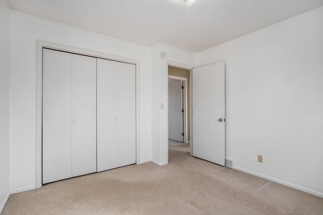 unfurnished bedroom featuring a closet, baseboards, and carpet flooring