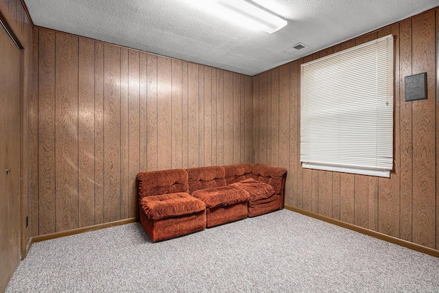 sitting room with visible vents, baseboards, a textured ceiling, and carpet