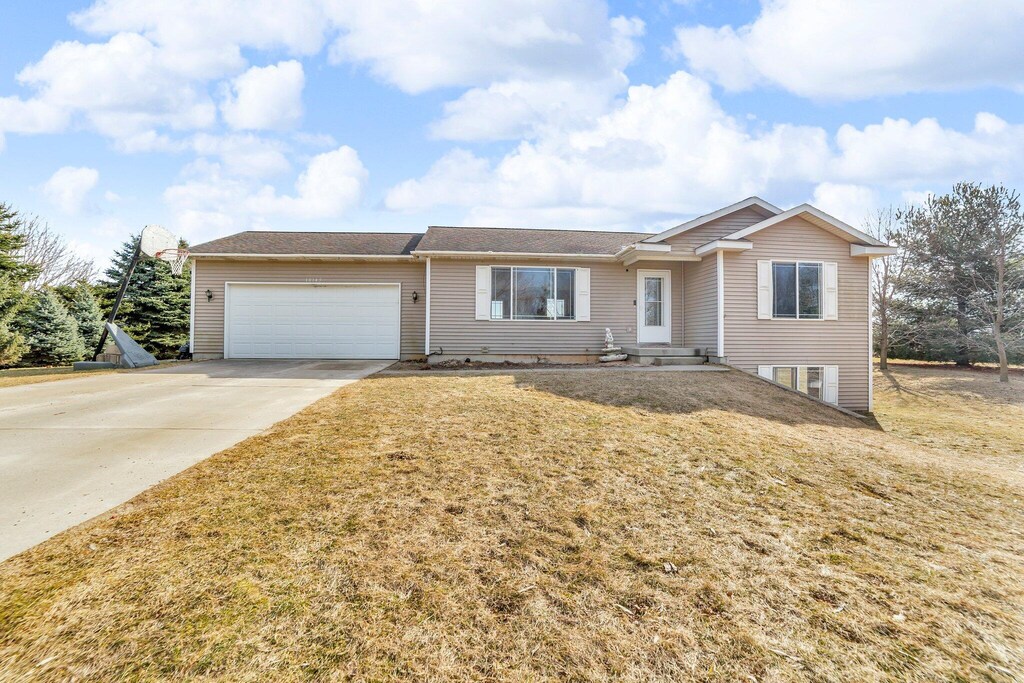10145 Portland Rd, Clarksville, MI 48815 - single story home with driveway, a front lawn, and a garage