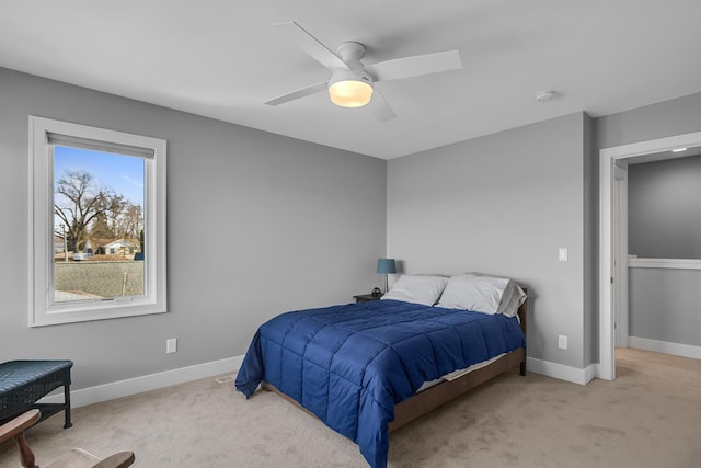 bedroom with ceiling fan, baseboards, and light carpet