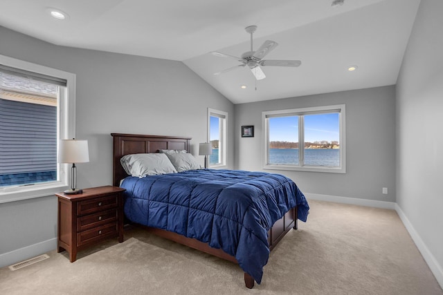 bedroom with lofted ceiling, light colored carpet, visible vents, and baseboards