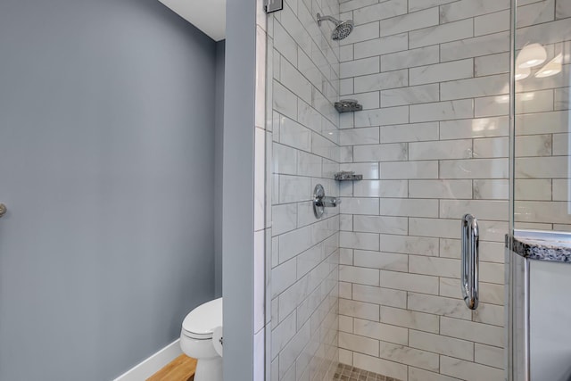 full bathroom featuring a shower stall, toilet, and baseboards