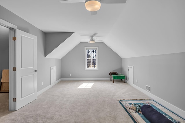 additional living space featuring visible vents, carpet floors, baseboards, ceiling fan, and vaulted ceiling