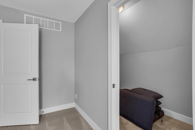 interior space with vaulted ceiling, carpet flooring, baseboards, and visible vents