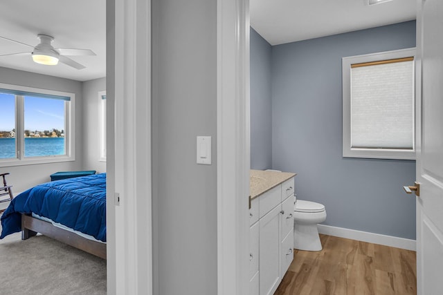 bathroom with vanity, a ceiling fan, wood finished floors, baseboards, and toilet