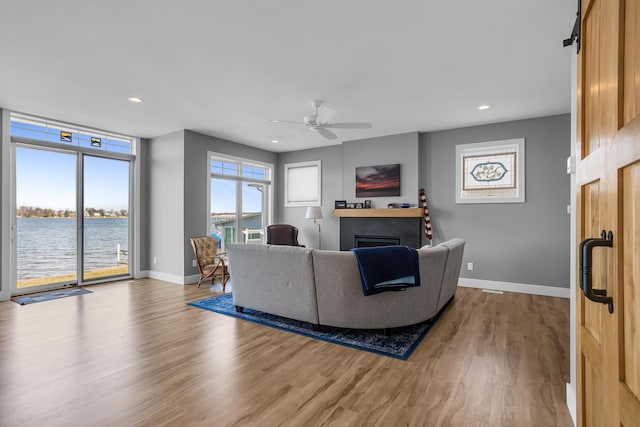 living room with a ceiling fan, wood finished floors, recessed lighting, a fireplace, and baseboards