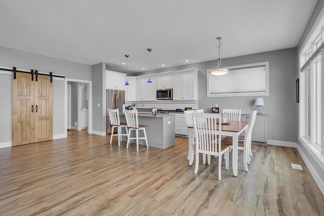 dining space featuring recessed lighting, light wood-type flooring, and baseboards