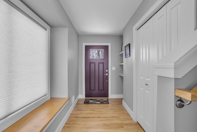 foyer entrance featuring visible vents, baseboards, and light wood finished floors