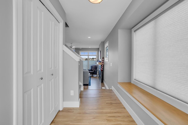 hallway featuring recessed lighting, baseboards, and light wood-style floors