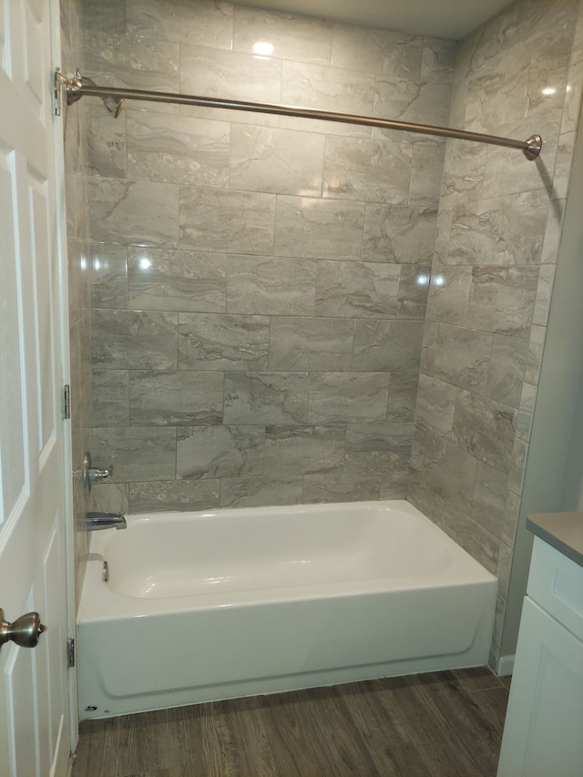 bathroom with tub / shower combination, vanity, and wood finished floors