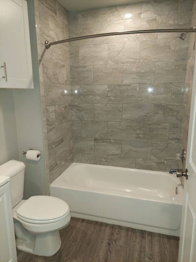 full bath with toilet, wood finished floors, and bathing tub / shower combination