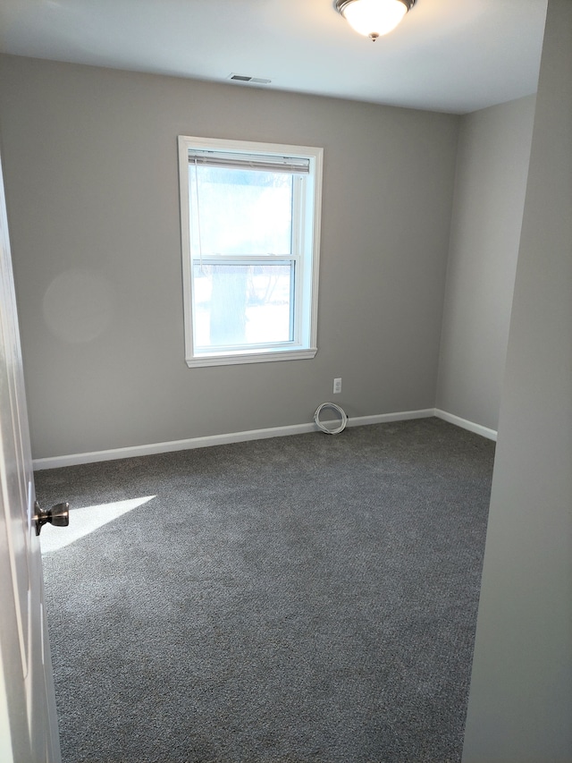 empty room featuring visible vents, baseboards, and carpet