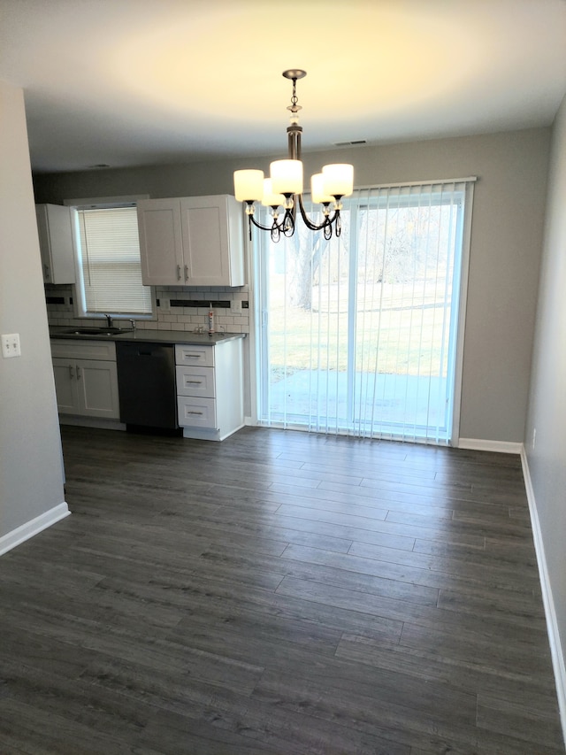 kitchen with decorative backsplash, dark wood-type flooring, dishwasher, and a chandelier