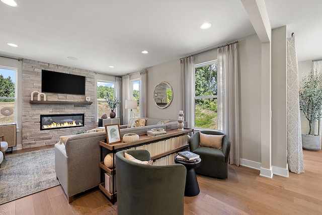 living area with a fireplace, recessed lighting, wood finished floors, and a wealth of natural light