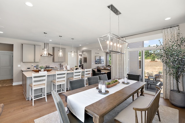 dining area with a chandelier, recessed lighting, baseboards, and light wood-style floors