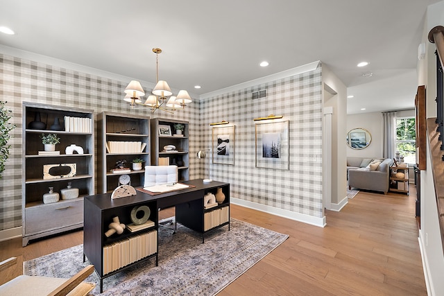 office with baseboards, wallpapered walls, an accent wall, light wood-type flooring, and a chandelier