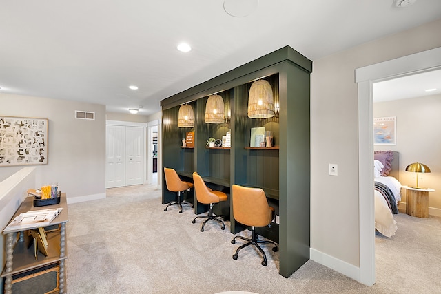 office space with visible vents, baseboards, light carpet, built in desk, and recessed lighting