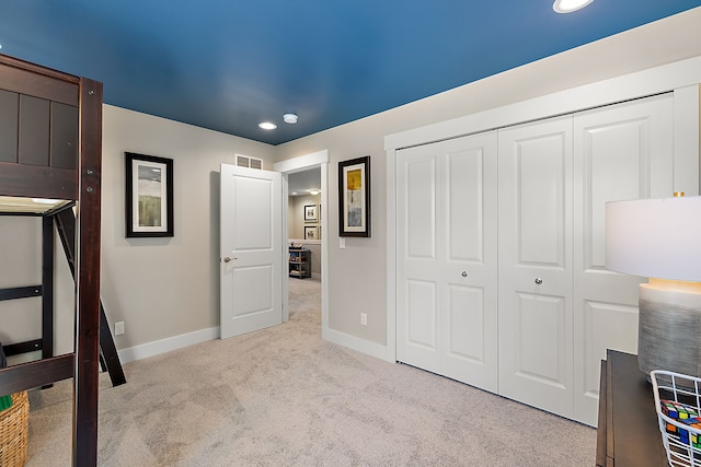 bedroom featuring a closet, visible vents, baseboards, and carpet floors