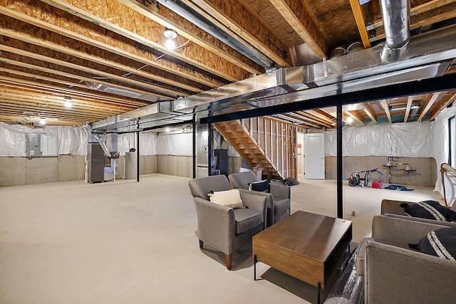 unfinished basement with heating unit, stairway, and electric panel