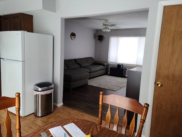 living area with light wood-style floors and a ceiling fan