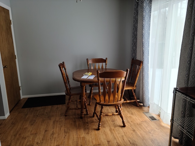 dining space featuring visible vents, baseboards, and wood finished floors