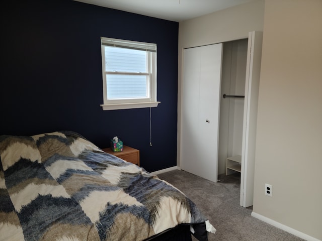 bedroom with a closet, carpet flooring, and baseboards