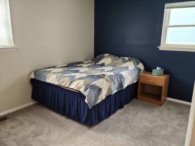 bedroom featuring baseboards, multiple windows, carpet, and visible vents